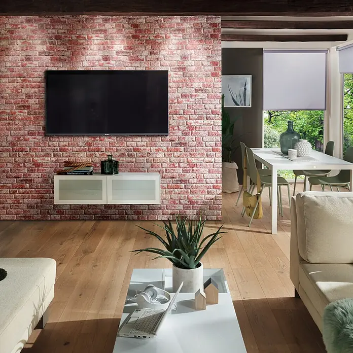 Panel de pared Ultra Light Brick - 120 x 50 cm, 2 ud. - Una elegante sala de estar con una moderna mesa de centro blanca con un ordenador portátil y unos auriculares encima.