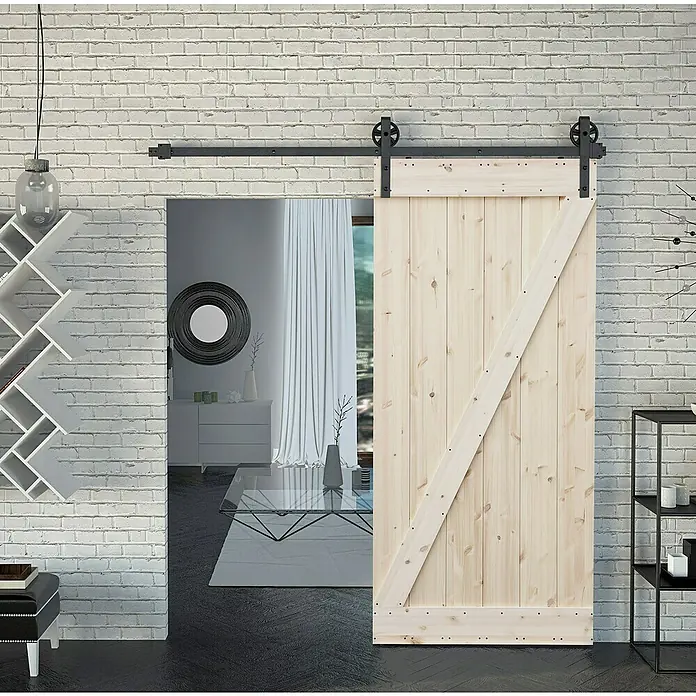 Radex Holzschiebetür Barn Door Loft Rustic - 95 x 210 cm, Kiefer, Natur, Motiv: Z - Eine helle Holztür im Scheunenstil mit schwarzer Schiene, die an einer weißen Ziegelwand befestigt ist, verleiht dem Raum einen rustikalen Charme.
