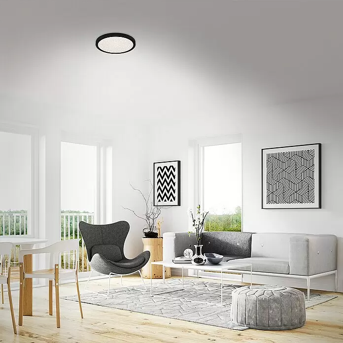 Briloner LED-Deckenleuchte rund RUNA - 18,5 W, Ø x H: 28 x 4 cm, Schwarz, Neutralweiß - Runde schwarze Deckenleuchte mit funkelndem Diffusor, die ein modernes Wohnzimmer beleuchtet.