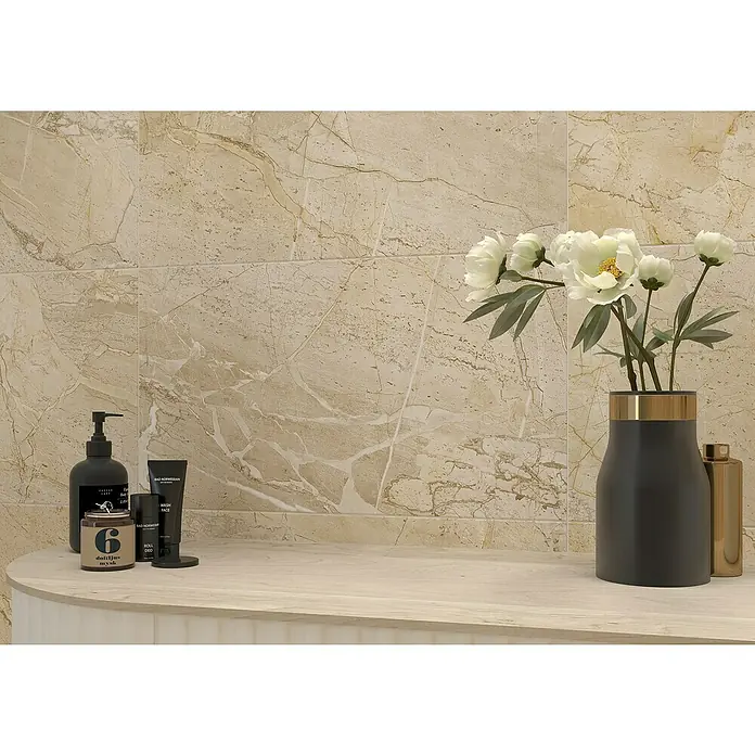 Feinsteinzeugfliese Side - 30 x 60 cm, Sand, Matt - Eine elegante Badezimmerausstattung mit Seifenspender, Kerze, Hautpflegeprodukten und einer Vase mit Blumen vor einer Marmorwand.