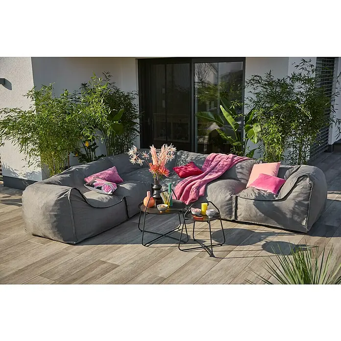 Loungesofa Modul - 107 x 107 x 72 cm, Polyesterfaser, Grau, Eckelement - Graues Outdoor-Ecksofa mit Zierkissen und Beistelltischen auf einer Terrasse, umgeben von üppigem Grün.