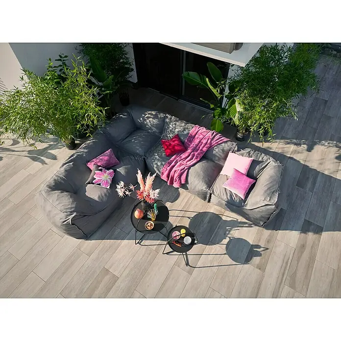 Loungesofa Modul - 107 x 107 x 72 cm, Polyesterfaser, Grau, Eckelement - Luftaufnahme eines modularen grauen Outdoor-Sofas mit farbenfrohen Kissen und Beistelltischen auf einer Terrasse.