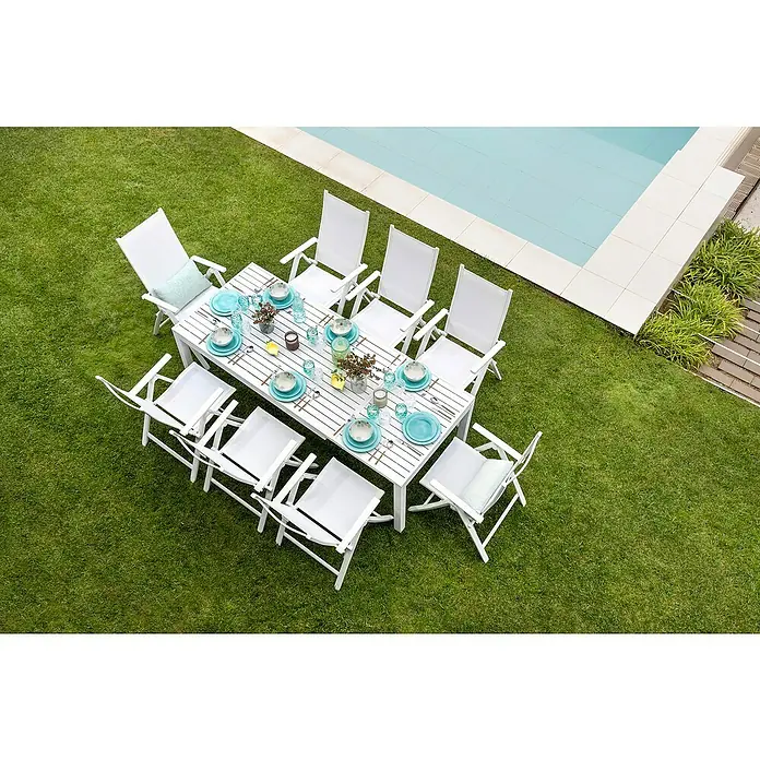 Sunfun Maja Sillón de posiciones - 61 x 68 x 110 cm, Blanco, Aluminio/Textiline - Un juego de comedor al aire libre con mesa blanca, sillas y vajilla azul cerca de una piscina, perfecto para comidas al aire libre.
