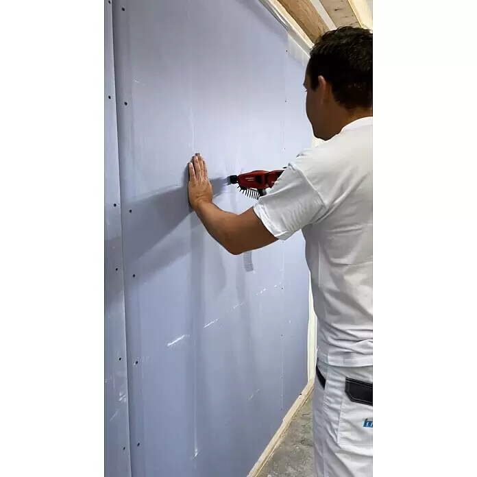 Knauf Schnellbauschraube TN 35 - Durchmesser: 3,9 mm, Länge: 35 mm, 250 Stk. - Person verwendet einen roten Hilti Schrauber, um in eine graue Trockenbauwand zu schrauben.