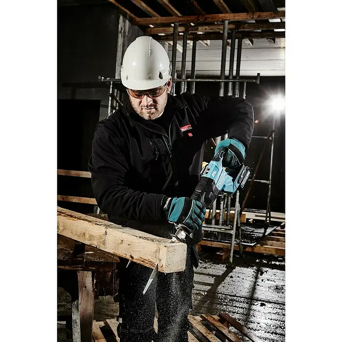 Makita XGT 40V max. Akku-Säbelsäge JR001GZ - 40 V, Ohne Akku, Leerlaufhubzahl: 0 /min - 3.000 /min - Ein Bauarbeiter mit Schutzhelm und Schutzbrille sägt mit einer Makita Säbelsäge ein Holzbrett.