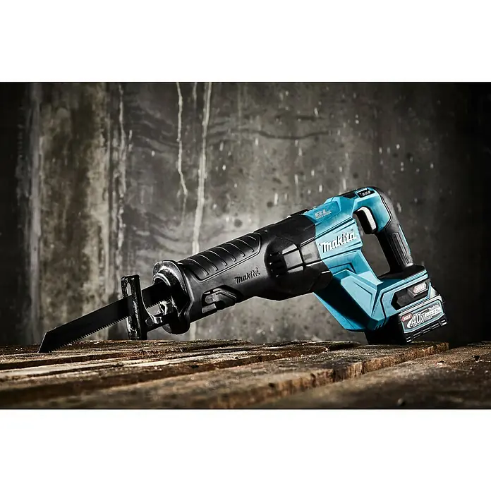 Makita XGT 40V max. Akku-Säbelsäge JR001GZ - 40 V, Ohne Akku, Leerlaufhubzahl: 0 /min - 3.000 /min - Nahaufnahme einer Makita Akku-Säbelsäge auf einem Holzboden vor einer grauen Wand.