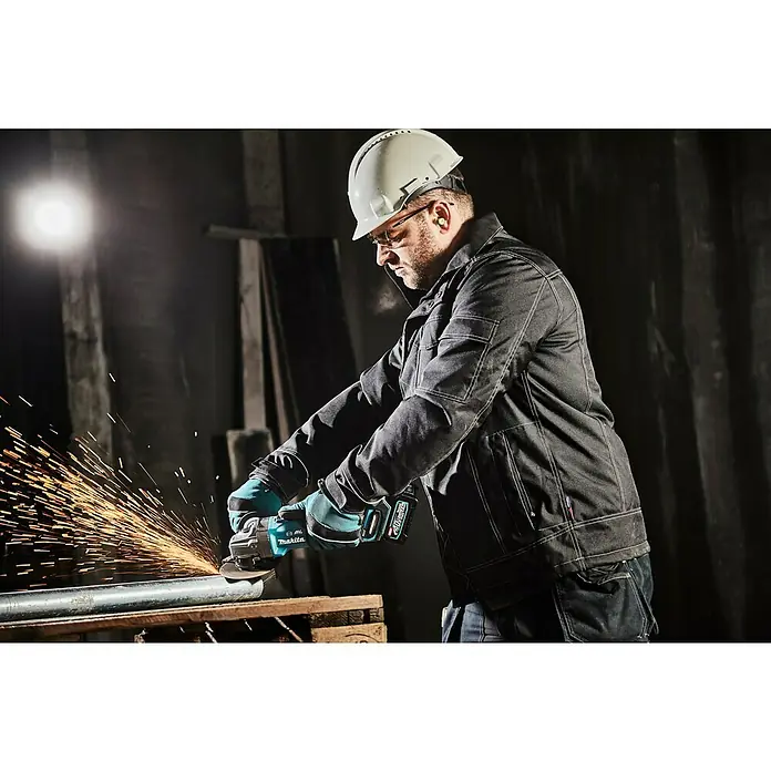 Makita XGT 40V max. Akku-Winkelschleifer GA005GM201 - 2 Akkus, 4 Ah, Leerlaufdrehzahl: 8.500 U/min - Ein Bauarbeiter benutzt eine Makita-Flex zum Schneiden eines Metallrohrs. Funken sprühen, während er arbeitet.
