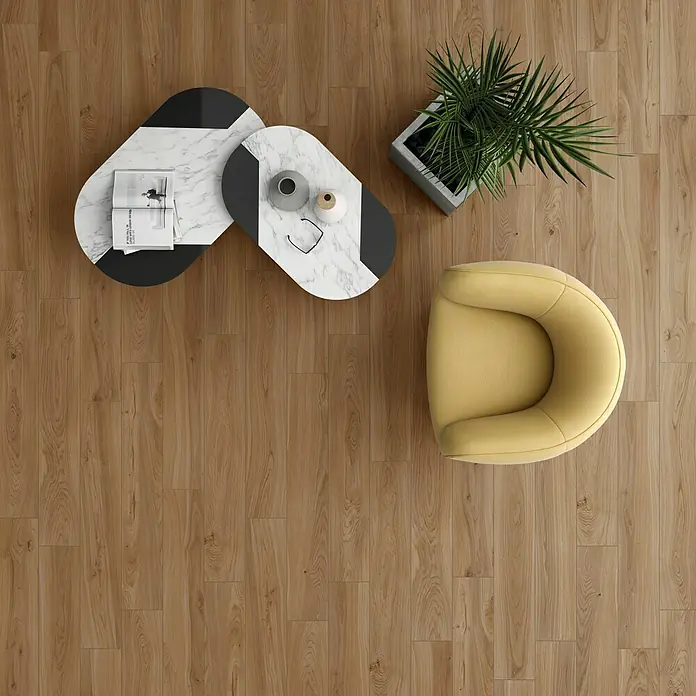 Pavimento porcelánico Miro - 120 x 20 cm, Fuoco, Mate, Rectificado - Vista superior de un sillón amarillo, mesas de centro y una planta de interior sobre un suelo de madera.