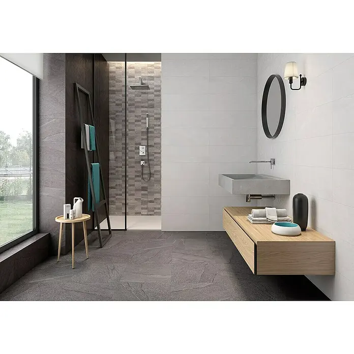 Pavimento cerámico Akane - 45 x 45 cm, Grafito, Mate - Un baño elegante con baldosas grises, un tocador flotante moderno y una ducha a ras de suelo. El diseño es minimalista y contemporáneo.