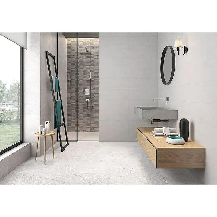 Pavimento cerámico Akane - 45 x 45 cm, Blanco, Mate - Un baño moderno con azulejos grises, una ducha con mampara de cristal y un lavabo con mueble de madera.
