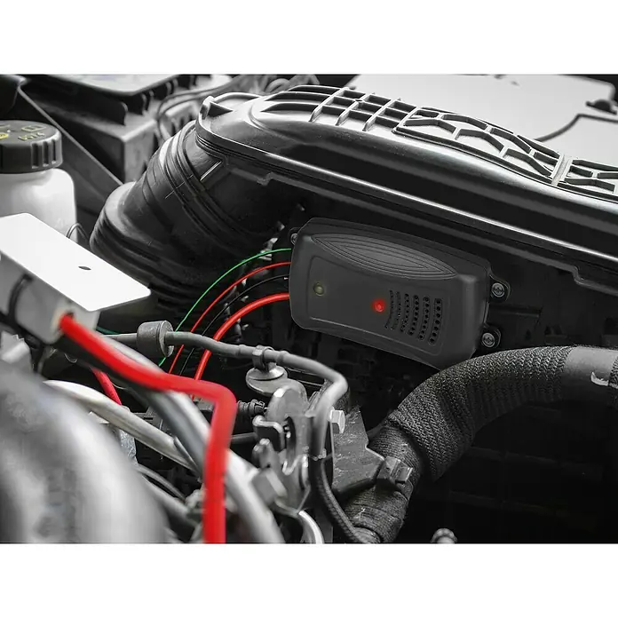 Marder Schreck Marderstop Kfz Hochspannung - Schalldruckpegel: 95 dB - Nahaufnahme eines montierten, elektronischen Geräts im Motorraum eines Autos mit sichtbarer Verkabelung.