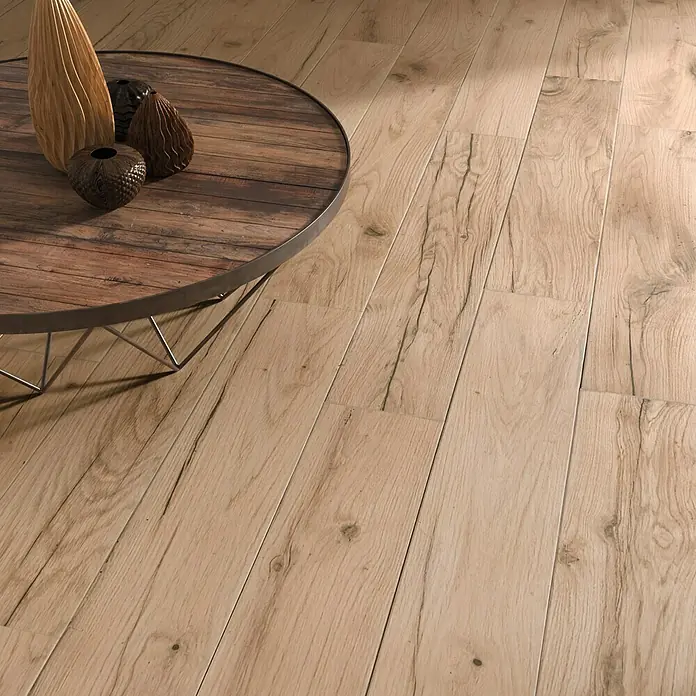 Pavimento porcelánico Genuine - 23,3 x 120 cm, Natural, Mate - Elegante mesa redonda con jarrones decorativos sobre un suelo con un atractivo diseño de madera. Ideal para espacios acogedores.