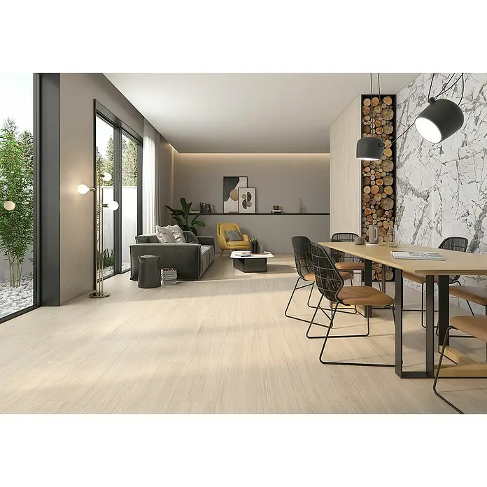 Pavimento porcelánico Bosco - 24 x 88 cm, Invierno, Mate - Amplio salón con suelos de madera clara, sofá moderno, mesa de comedor con sillas y una pared decorativa con leña apilada.