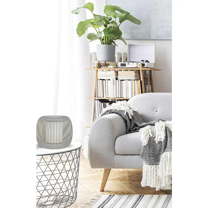 Idp Lampshades Lámpara de sobremesa Juliette - 40 W, L x An x Al: 27 x 27 x 22 cm, Gris, E27 - Una moderna lámpara gris sobre una mesa auxiliar de alambre, junto a un sillón gris y una estantería.