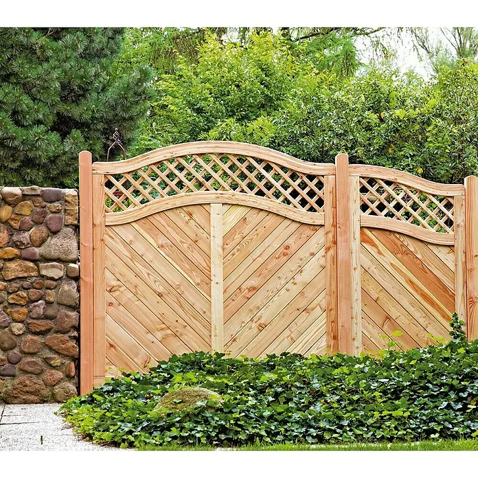 T & J Sichtschutzelement Skagen - B x H: 180 x 150 cm, Holz, Natur - Holzzaun mit dekorativem Gittermuster und diagonalen Brettern, umgeben von üppigem Grün. Ideal als stilvolle Garteneinfassung.