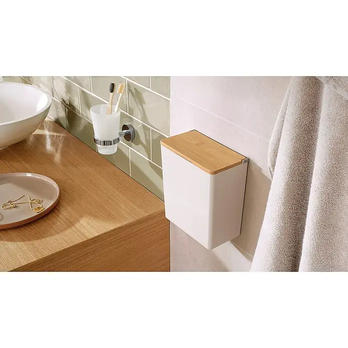 Tesa Caja de almacenaje Baboo L - L x An x Al: 21 x 10,2 x 18,2 cm, Plástico, Blanco - Un cubo de basura de baño con tapa de madera cuelga de la pared, junto a un lavabo y un toallero.