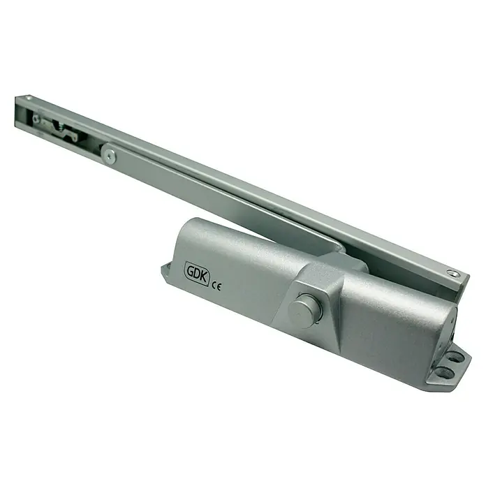 GDK Cerrador de puertas V68 - Plateado, Anchura de puerta máx.: 85 cm, Control deslizante - Un cierrapuertas plateado GDK con un brazo que se extiende desde la carcasa. Ideal para edificios comerciales y cierre fiable.