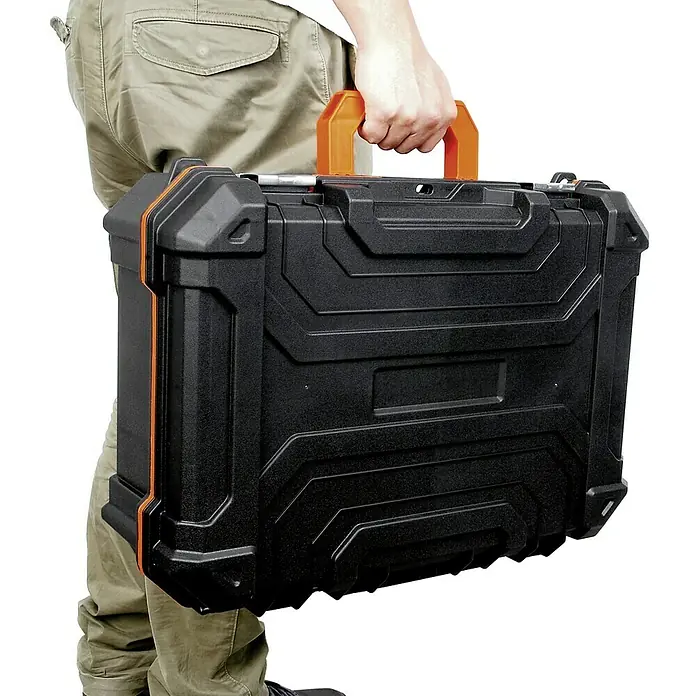 Lockweiler Werkzeugkoffer Tool Box DC 202 - L x B x H: 39 x 49 x 19 cm, Polypropylen, Ohne Werkzeug - Eine Person trägt einen robusten, schwarzen Werkzeugkoffer mit orangefarbenem Griff. Der Koffer hat ein strukturiertes Design.