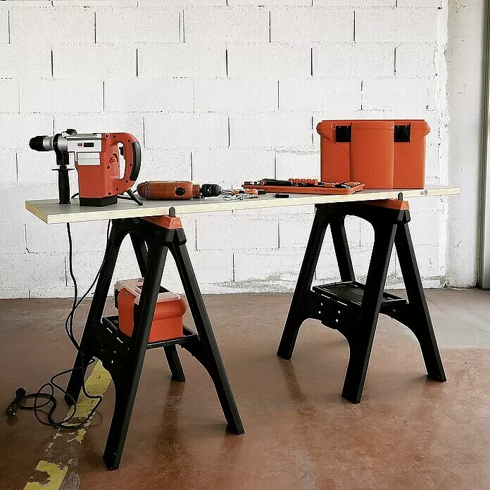 Lockweiler Unterstellbock SH 020 - Belastbarkeit: 200 kg, 2 Stk. - Zwei schwarze Kunststoff-Arbeitsböcke bilden eine mobile Werkbank mit Holzplatte, auf der Elektrowerkzeuge und eine Werkzeugkiste liegen.