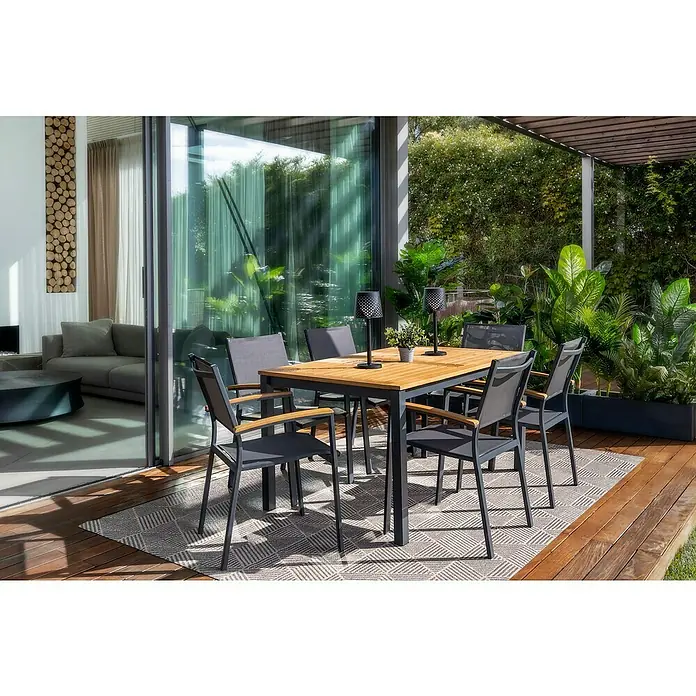 Silla de jardín Ariadna - Antracita / Marrón natural, Eucalipto, Apilable - Acogedor espacio exterior con un elegante conjunto de mesa de comedor de madera y metal, complementado con lámparas de mesa ambientales y vegetación exuberante.