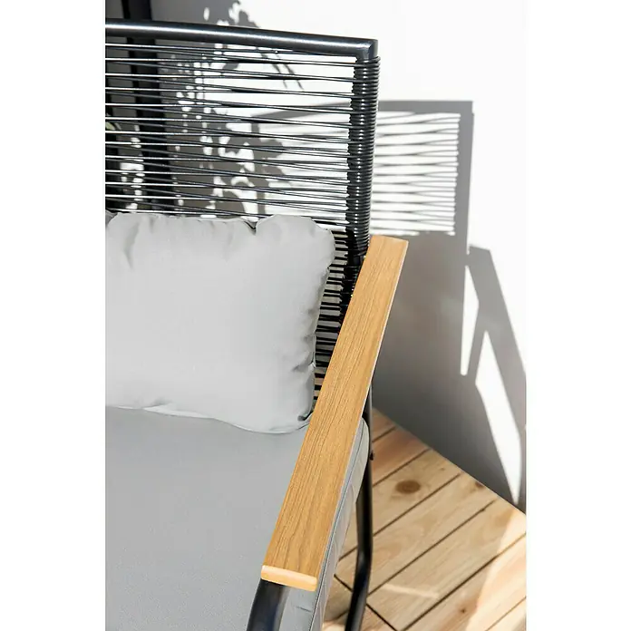 Sunfun Conjunto de muebles Susana - 4 pzs., Acero/Polywood, Negro - Primer plano de una silla de exterior con cojín gris y reposabrazos de madera, invitando a relajarse al aire libre.