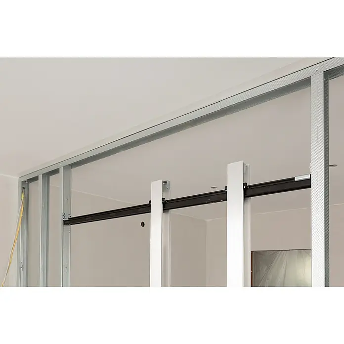 Knauf Klemmbacken Pocket Kit - Belastbarkeit pro Tür: 120 kg, Passend für: Glastürblätter mit Glasdicken 8/10/12 mm VSG/ESG - Ein Blick auf eine unfertige Wand mit einem Ständerwerk aus Metallprofilen, das die Struktur für den Trockenbau bildet.