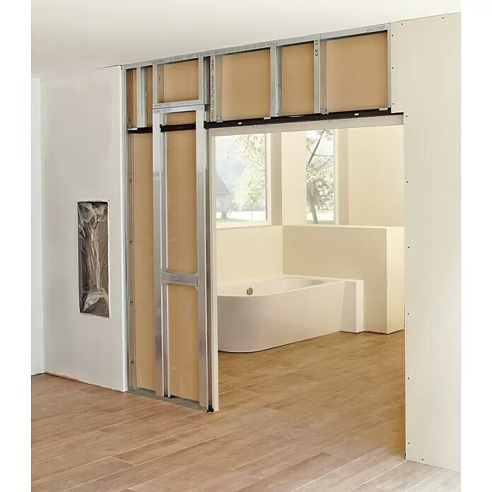 Knauf Klemmbacken Pocket Kit - Belastbarkeit pro Tür: 120 kg, Passend für: Glastürblätter mit Glasdicken 8/10/12 mm VSG/ESG - Metalleinschubtürrahmen in einer Innenwand während des Baus installiert, mit Badewanne im Nebenraum sichtbar.