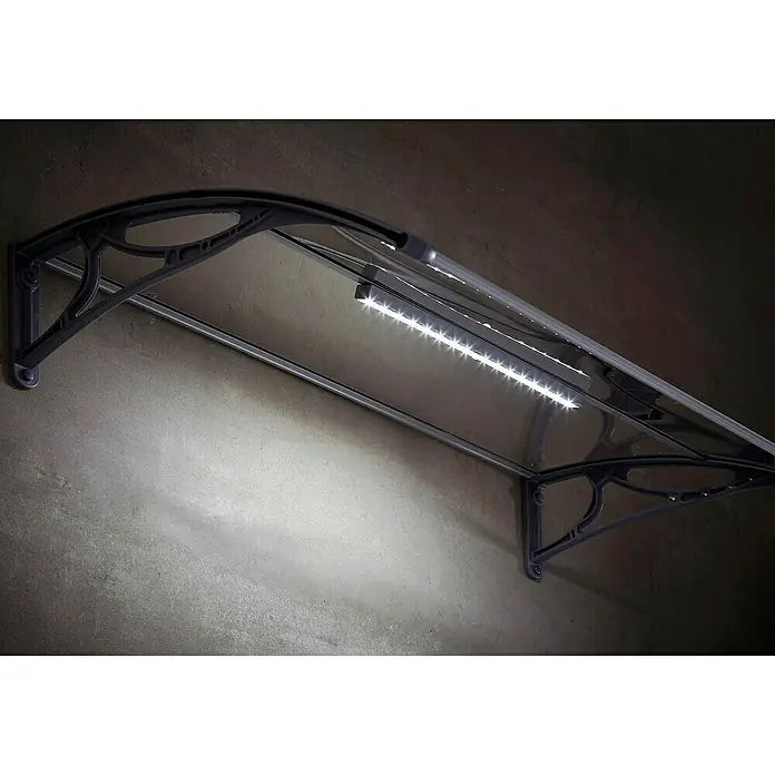 Superroof Pultvordach Formentor mit LED - 120 x 74 x 28,5 cm, Grau - Ein Vordach mit integrierter LED-Beleuchtung, das über einer grauen Wand montiert ist, bietet Schutz und modernes Design.