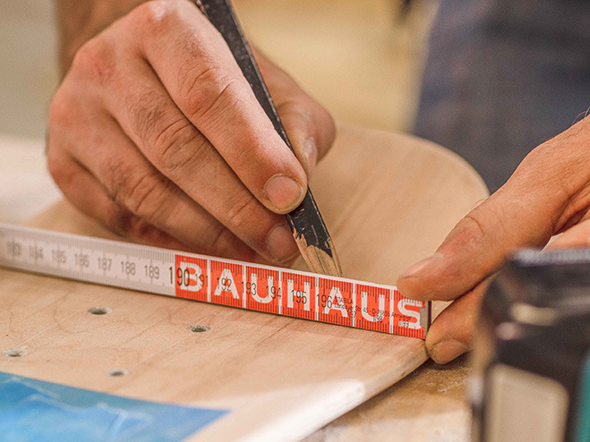 Mit Hilfe eines Bleistifts werden Löcher auf dem Skateboard angezeichnet