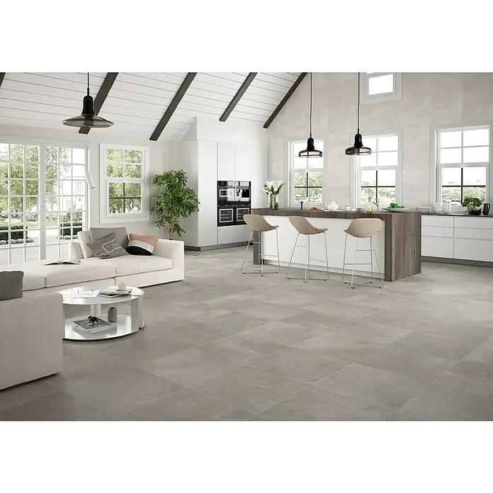 Revestimiento de pared Rodano - 30 x 60 cm, Light grey, Mate - Luminosa y moderna sala de estar con baldosas grises que crean un aspecto elegante y contemporáneo. El espacio abierto está lleno de luz natural.