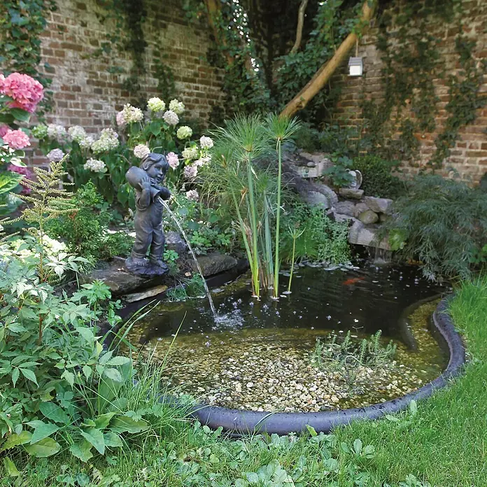 Ubbink Teichschale Iris SI - Fassungsvermögen: 150 l - Gartenteich mit einer Jungenstatue als Wasserspeier, umgeben von üppiger Vegetation und einem kleinen Wasserfall.