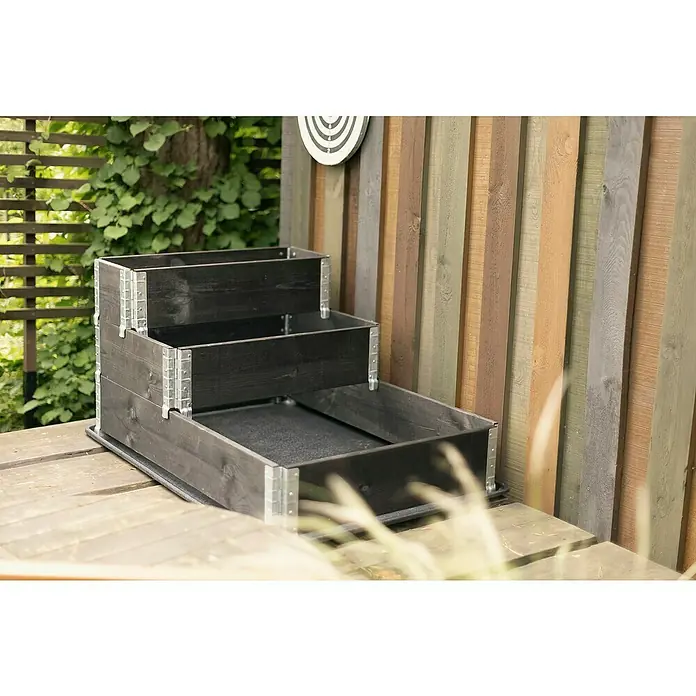 Upyard Hochbeet 3 Ebenen - 120 x 80 x 58,5 cm, Holz, Schwarz, Fassungsvermögen: 302,4 l - Ein dreistufiger, schwarzer Pflanzkasten aus Holz mit Metallecken auf einer Holzterrasse, ideal für Kräuter oder Blumen.