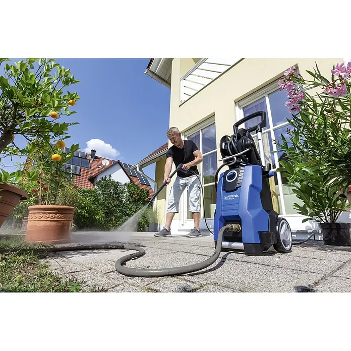 Nilfisk Hochdruckreiniger E 145.4-9 Power X-Tra - 145 bar, 2.100 W, Fördermenge: 500 l/h - Der Nilfisk Hochdruckreiniger im Einsatz auf einer Terrasse, ideal für die Reinigung von Außenbereichen und Oberflächen.