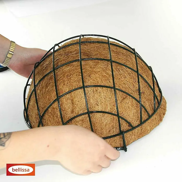 Bellissa Blumenampel Hanging Basket - Ø x H: 35 x 15 cm, Metall, Schwarz - Nahaufnahme eines Kokosfaser-Pflanzkorbs mit schwarzem Drahtgestell, der von Händen gehalten wird und die natürliche Textur und robuste Bauweise hervorhebt.