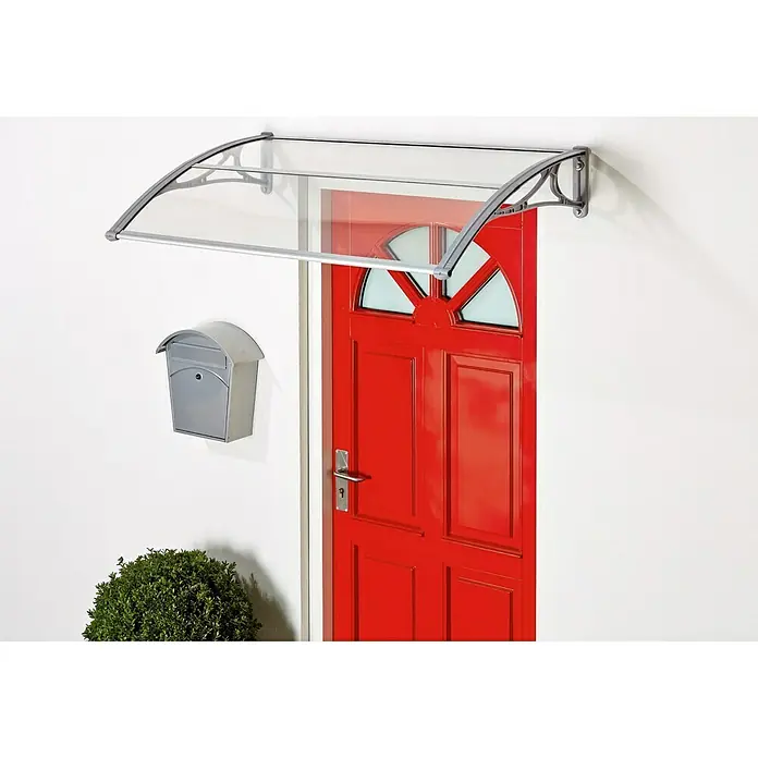 Superroof Pultvordach Formentor mit LED - 120 x 74 x 28,5 cm, Grau - Das Bild zeigt ein modernes, graues Türvordach mit einer transparenten Abdeckung über einer roten Tür mit Briefkasten an einer weißen Wand.