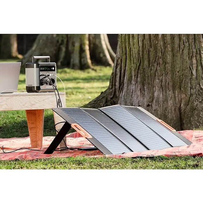 Yard Force Powerstation LX PS600 - 518 Wh, Nennleistung: 600 W, Max. Leistung: 1.200 W - Tragbare Powerstation mit Solarpanel auf einer Picknickdecke im Freien, ideal für Camping und netzunabhängige Stromversorgung.
