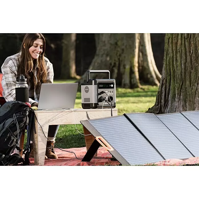 Yard Force Powerstation LX PS1200 - 974,4 Wh, Nennleistung: 1.200 W, Max. Leistung: 2.400 W - Eine tragbare Powerstation und faltbare Solarmodule versorgen einen Laptop im Freien mit Strom.