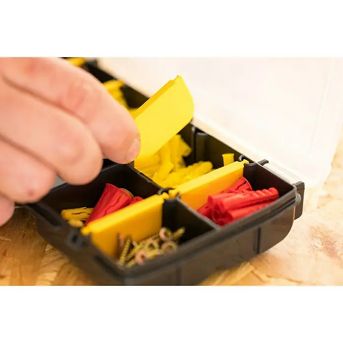 Stanley Kleinteilekoffer - Anzahl Fächer: 10 Stk., Ohne Inhalt, Schwarz/Gelb - Eine Hand greift in eine Sortimentsbox mit Dübeln und Schrauben, ideal für Heimwerker und Profis.
