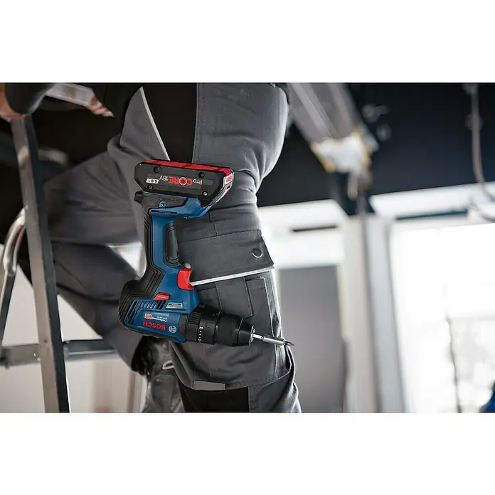 Bosch Professional Set de taladros GDX18V-200+GSB18V-55 - 18 V, 2 baterías, 4 Ah, 5 pzs. - Primer plano de un taladro/atornillador inalámbrico Bosch Professional con batería, sujeto a los pantalones de un artesano subido a una escalera.