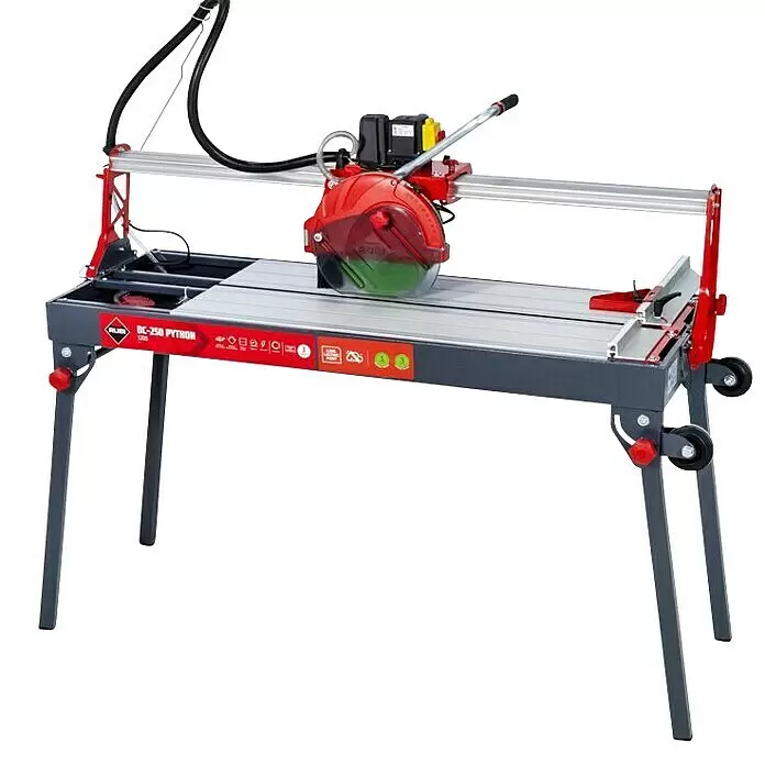 Rubi Cortador de azulejos eléctrico DC-250 Python 1200 - 1.100 W, Longitud de corte máx.: 1.210 mm, Profundidad de corte a 90 °: 90 mm - Cortadora de azulejos eléctrica RUBI DC-250 PYTHON: marco rojo y gris, mesa de corte plateada, protector de hoja rojo y ruedas.