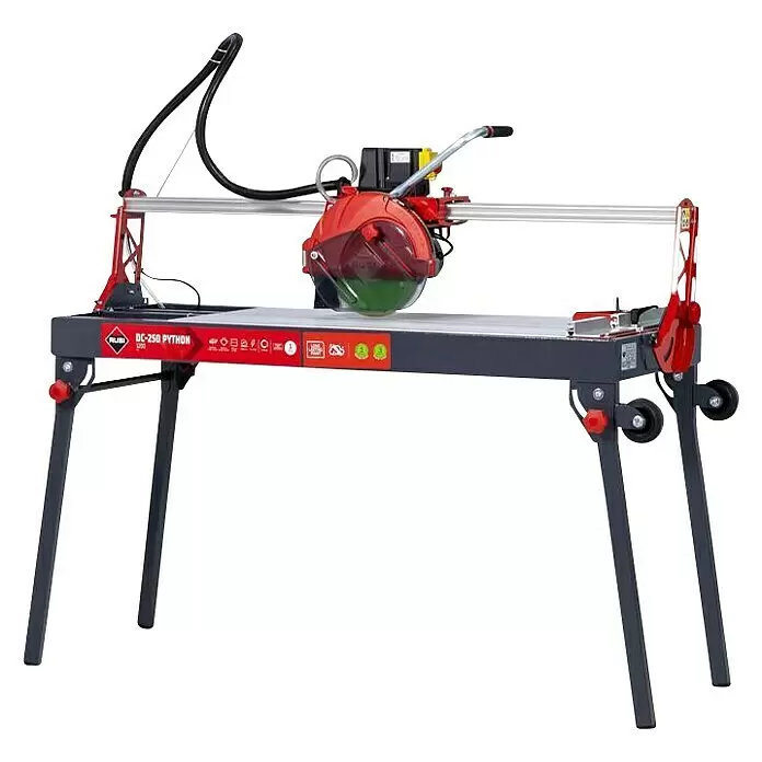 Rubi Cortador de azulejos eléctrico DC-250 Python 1200 - 1.100 W, Longitud de corte máx.: 1.210 mm, Profundidad de corte a 90 °: 90 mm - Sierra eléctrica para azulejos RUBI DC-250 PYTHON roja y gris sobre soporte con ruedas, con carril de corte y hoja circular.