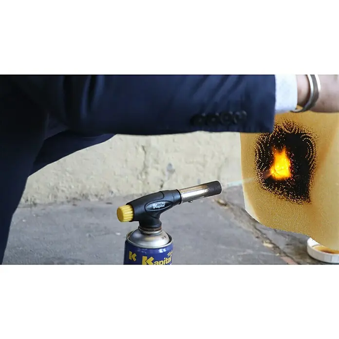 Simonrack Ecofire Extintor de incendios Home - 1 l - Un hombre en traje enciende un trozo de material que parece derretirse con un soplete de la marca "Kapital".