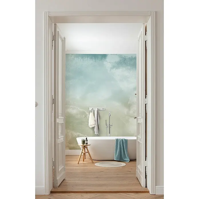 Komar Infinity 2 Fototapete Broken Blend - B x H: 400 x 250 cm, Vlies - Blick durch eine offene Tür auf ein Badezimmer mit freistehender Badewanne, verziert mit einem himmelblauen Wandbild, das eine ruhige Atmosphäre schafft.