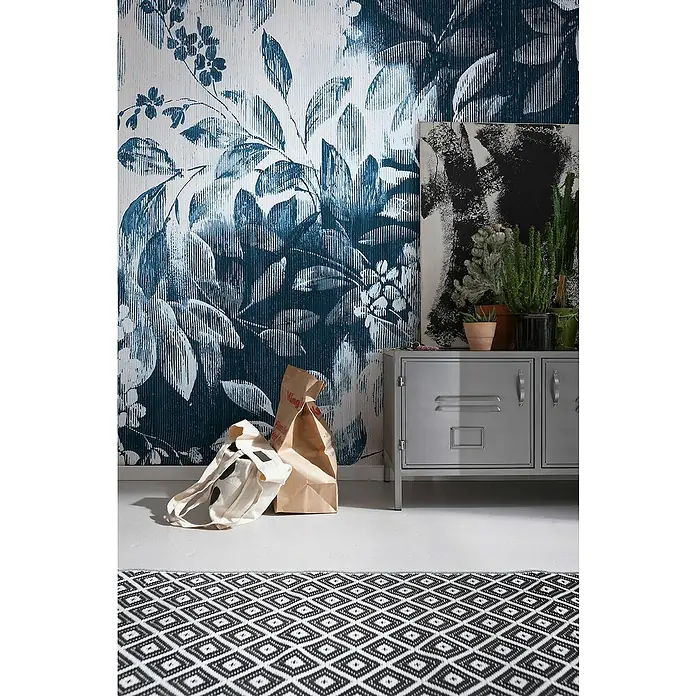 Komar Infinity 2 Fototapete Idyllic Indigo - B x H: 200 x 250 cm, Vlies - Stylische graue Anrichte vor einer blau-weißen floralen Wand, ergänzt durch eine auffällige schwarz-weiße Teppich.