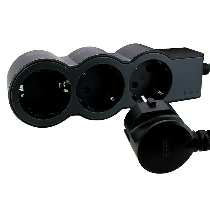Legrand Base de enchufe múltiple Standard - Negro, Longitud del cable: 1,5 m, Número de enchufes Schuko: 3 ud. - Regleta negra Legrand con tres enchufes y un enchufe insertado, sobre un fondo negro.
