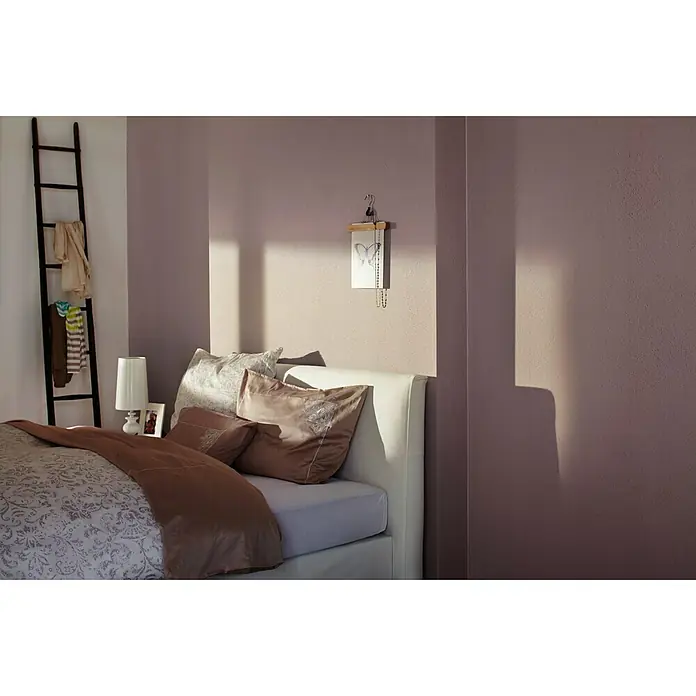 Knauf Putz-Abtönfarbe Compact Color - Muschel, 6 g - Blick auf ein Schlafzimmer mit einem bequemen Bett, das mit Kissen und einer Tagesdecke geschmückt ist, die zum Entspannen einlädt.