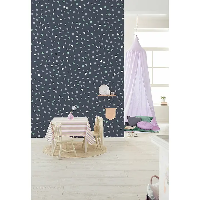Komar Infinity 2 Fototapete Dotty DanceB x H: 200 x 250 cm, Vlies - Kinderzimmer mit dunkelblauer Tapete mit bunten Tupfen, Kindertisch mit Stühlen und Baldachin über Kissen in der Ecke.