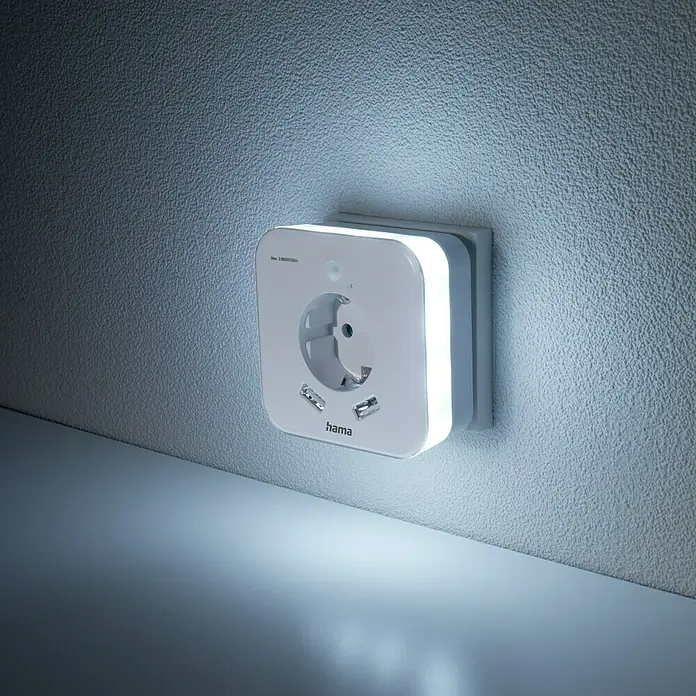 Hama LED-Nachtlicht mit Steckdose, USB, Bewegungs- und Lichtsensor - L x B x H: 7,5 x 8,5 x 8,5 cm, Tageslichtweiß - Produktbild: Eine Hama Steckdose mit USB-Anschlüssen und integriertem Nachtlicht an einer Wand.