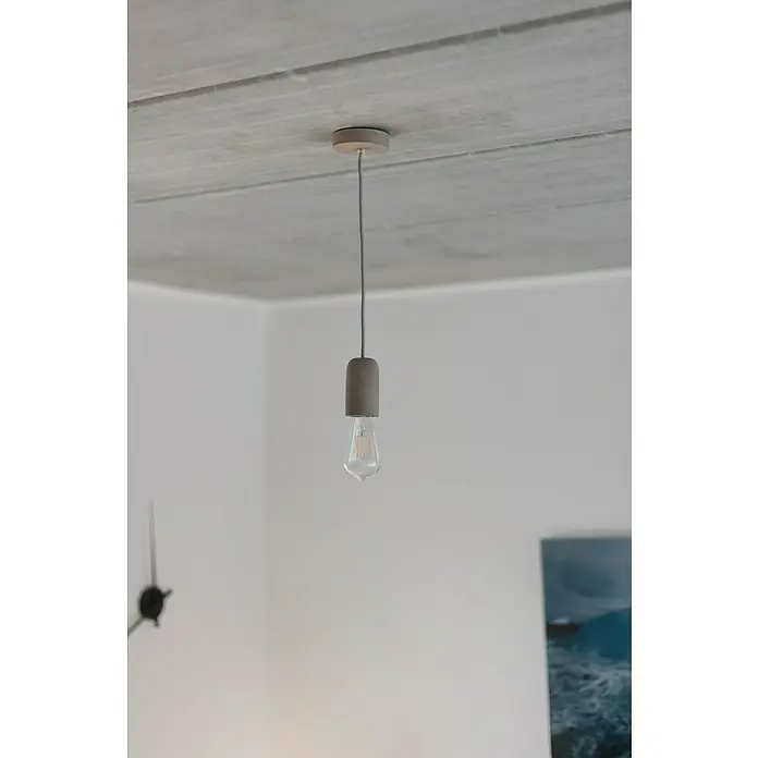 Chacon Casquillo de hormigón - Hormigón, Gris, 1 ud. - Una lámpara colgante minimalista con una bombilla Edison cuelga de un techo de concreto, dando un toque moderno.