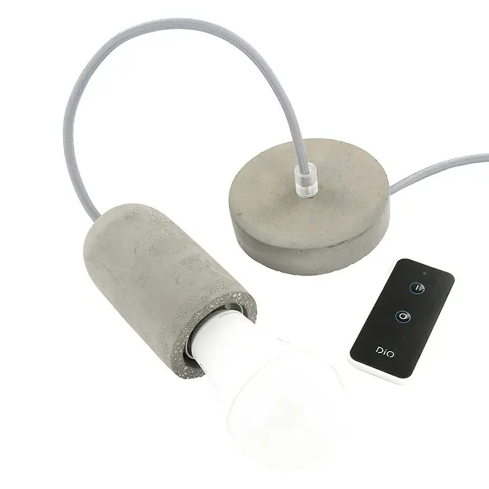 Chacon Casquillo de hormigón - Hormigón, Gris, 1 ud. - La imagen muestra una lámpara colgante de cemento gris moderna con una bombilla blanca y un control remoto.